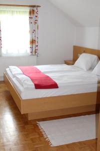 阿特湖赛尔灵格度假屋酒店的卧室里一张床上的红色毯子