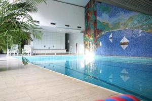 上哈茨山区舒伦贝格Sporthotel Schulenberg的墙上挂有壁画的游泳池