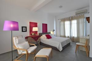 皮索利瓦迪阿斯普罗别墅的一间卧室配有一张床、椅子和紫色灯