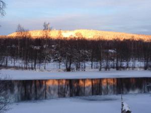 SmedjebackenLottas Rum的冬季日落,在湖上,山下