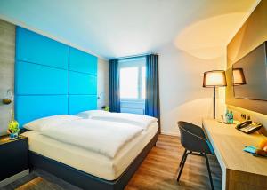 Rietheim-Weilheim旅程欢愉酒店的配有一张床和一张书桌的酒店客房