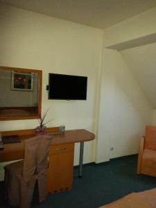 瓦拉日丁伊斯特拉酒店的一间设有一张桌子和一台墙上的电视的房间