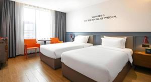 武汉Premier City Comfort Hotel Wuhan Hankou Railway Station Changgang Road Metro Station的酒店客房,设有两张床和一张橙色椅子