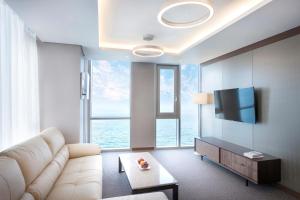 济州市海蓝丽景酒店的客厅配有白色沙发和大窗户