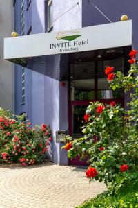 纽伦堡INVITE Hotel an der Kaiserburg的前方有红色花的建筑入口