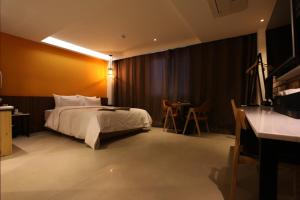 仁川市可可酒店的酒店客房配有一张床铺和一张桌子。