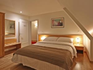 布勒Hôtel du Cheval Blanc - City center的一间卧室配有一张大床和两盏灯。