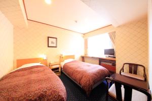 新泻新泻站酒店的酒店客房设有两张床和窗户。