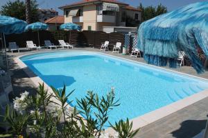 朱利亚诺瓦蓝色海洋公寓式酒店的一个带椅子和遮阳伞的大型游泳池