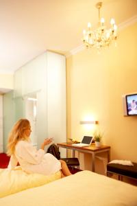 萨尔茨堡达斯格伦博斯特酒店赛科尼公寓式酒店的坐在酒店房间床上的女人