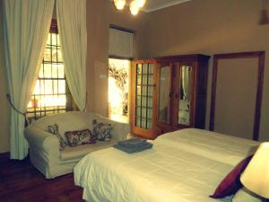 Ladybrand佳屋住宿加早餐酒店的一间卧室配有一张床、一张沙发和窗户。