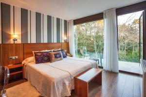 菲尼斯特雷阿伦多马尔酒店的一间卧室设有一张床和一个大窗户
