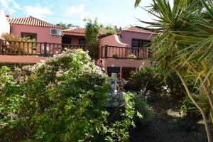 埃尔帕索Casa Bana I的粉红色的房子,设有阳台和一些植物