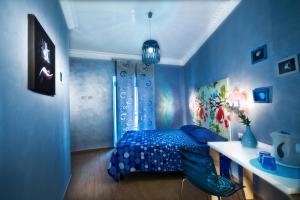 罗马多莫斯戴安娜酒店的蓝色卧室配有一张床和一张书桌