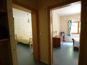 Taintrux拉切里奥勒旅舍的客房设有带一张床和一张书桌的卧室。
