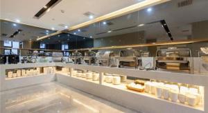 武汉Lavande Hotels Wuhan Guanggu Yangjiawan Metro Station的面包店柜台,展示着许多食物