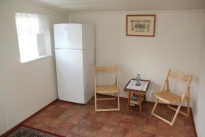 胡萨维克霍夫迪宾馆的厨房配有两把椅子和白色冰箱