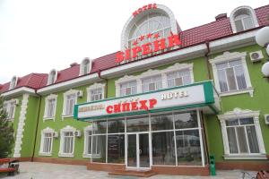 Chkalovsk斯贝尔酒店的一座绿色建筑,上面标有一家可笑的酒店