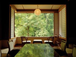 三条市嵐渓荘旅馆的配有大窗户的客房内的桌椅