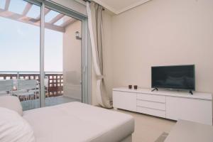 厄尔梅达诺Vista Roja的一间白色的房间,配有电视和白色沙发