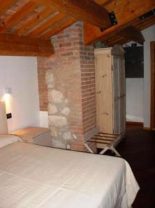 BrendolaTenuta Maraveja的一间卧室设有一张床和砖墙