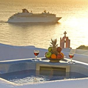 伊亚马瑞森窑洞及别墅酒店的一碗水果,两杯葡萄酒和一艘游轮