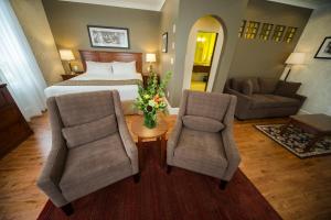 尼尔逊休姆酒店的酒店客房,配有一张床和两把椅子