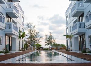 西哈努克玛丽海滩度假酒店的两栋建筑中间的游泳池