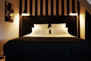 欧里亚克德斯卡默斯酒店的一张带黑色床头板和白色枕头的床