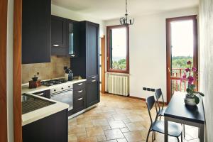 维罗纳Giardino Ferrari的厨房配有黑色橱柜和桌椅