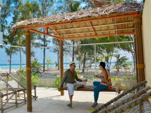 胡鲁马累呼尔胡维拉海滩椰子树酒店的坐在野餐桌上的男人和女人
