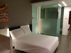 基耶蒂贝斯特韦斯特帕可帕格里亚酒店的卧室配有白色的床和玻璃墙