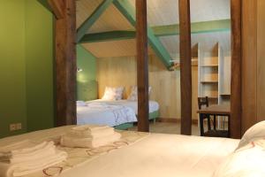 Saint-Michel-Saint-JaymesB&B La Ferme de la Patte d'Oie的一间卧室设有两张带绿色墙壁的床
