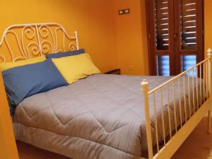 Montorio al VomanoLo Scoiattolo Country House的一张白色的床,上面有蓝色和黄色的枕头