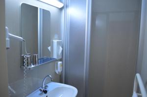 维也纳Hotel Donaustadt Kagran - at Metro U1的浴室配有盥洗盆和带镜子的淋浴