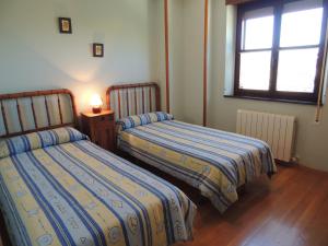 TarilonteEl Encinar的一间卧室设有两张床和窗户。