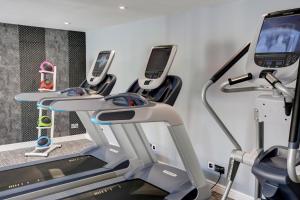 法纳姆Frensham Pond Country House Hotel & Spa的健身房里一排带手机的跑步机