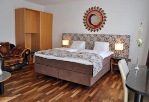 沃尔夫斯堡特维特旅馆的卧室配有一张床,墙上设有镜子
