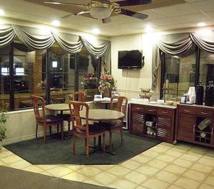 莱瑟姆Colonie Inn and Suites的一间带桌椅和电视的用餐室