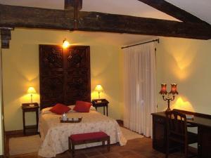 圣埃斯特万德尔瓦勒方块磨坊旅馆的一间卧室配有一张床、两张桌子和一张书桌