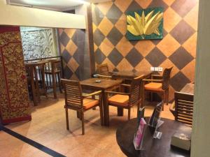 库塔库塔纱丽楼酒店的餐厅设有木桌、椅子和墙壁