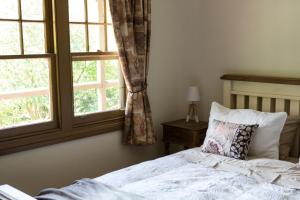 沃伯顿莨山住宿加早餐旅馆的一间卧室设有一张床和两个窗户。
