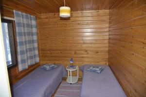 Juankoski泰尤图威特山林小屋的木墙客房的两张床