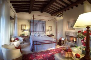 斯波莱托博尔戈德拉马尔莫塔酒店的一间卧室设有一张天蓬床和一个壁炉