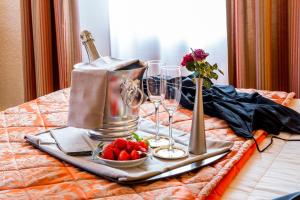 勒邦翁障眼法之家餐厅酒店的床上的托盘,上面装有酒杯和草莓