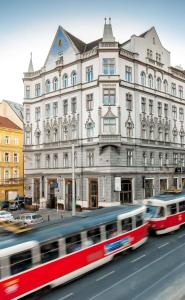 布拉格Czech Inn的一辆红色和白色的巴士驶过大楼