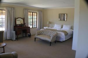 安德伯格Cedar Garden的一间卧室配有一张床、一把椅子和镜子