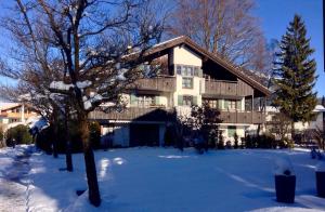 加尔米施-帕滕基兴Am Park的雪中大房子,有树