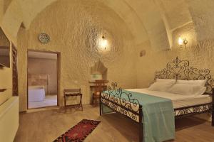 格雷梅Jacob's Cave Suites - Cappadocia的一间带大床的卧室,位于带拱门的房间