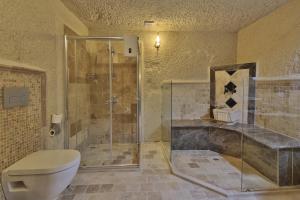 格雷梅Jacob's Cave Suites - Cappadocia的一间带卫生间和玻璃淋浴间的浴室